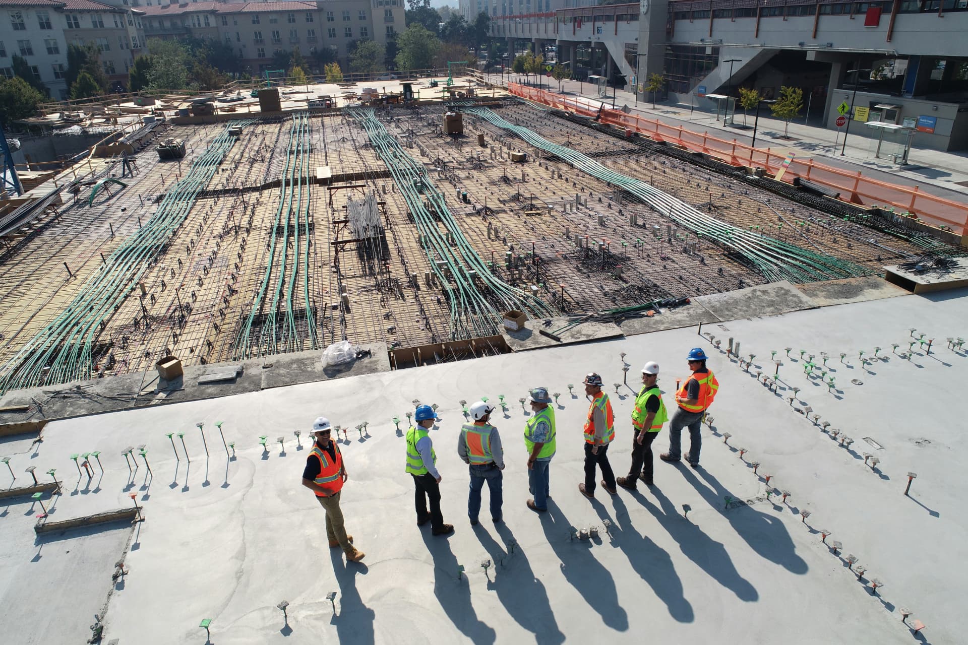 Engineering team in high-visibility equipment working together on a large construction site