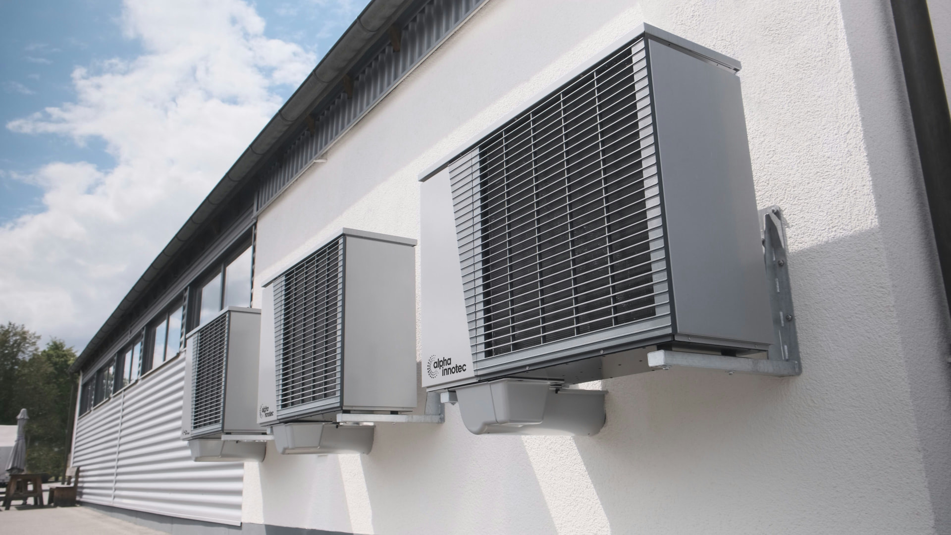 Row of external ventilation units mounted on the wall of an industrial building
